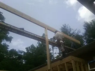 Carpenter setting a ridge beam over a new addition frame — Ice Dam Removal by Roofing Brothers in New Baltimore
