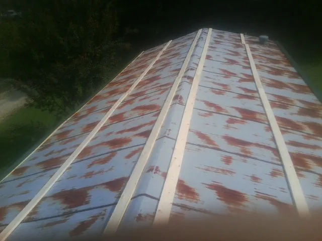 Rusted metal roof panels with new wood purlins before replacement — Storm Damage Roof Repair in New Baltimore by Roofing Brothers