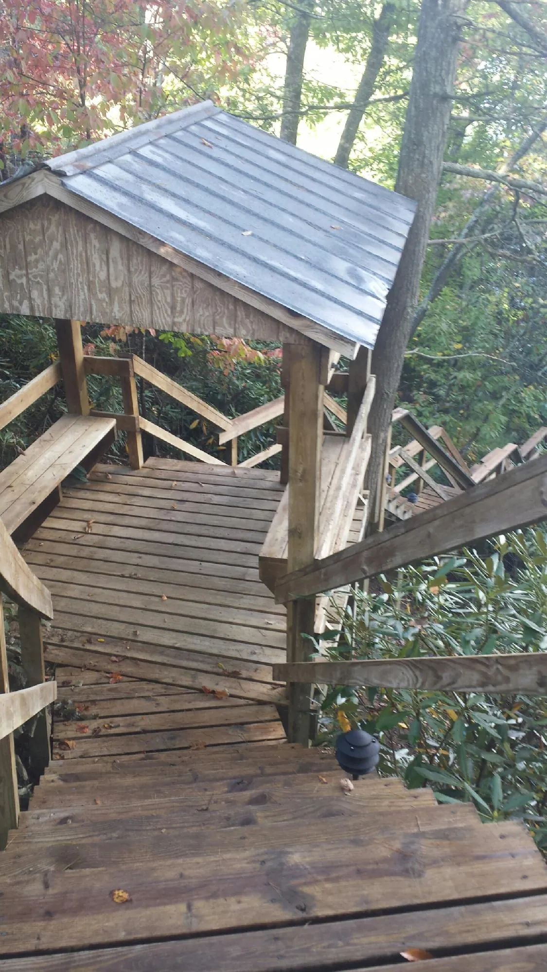 Metal roofed shelter over wooden steps on a wooded walkway — Skylight Repair & Installation work by our crew in New Baltimore